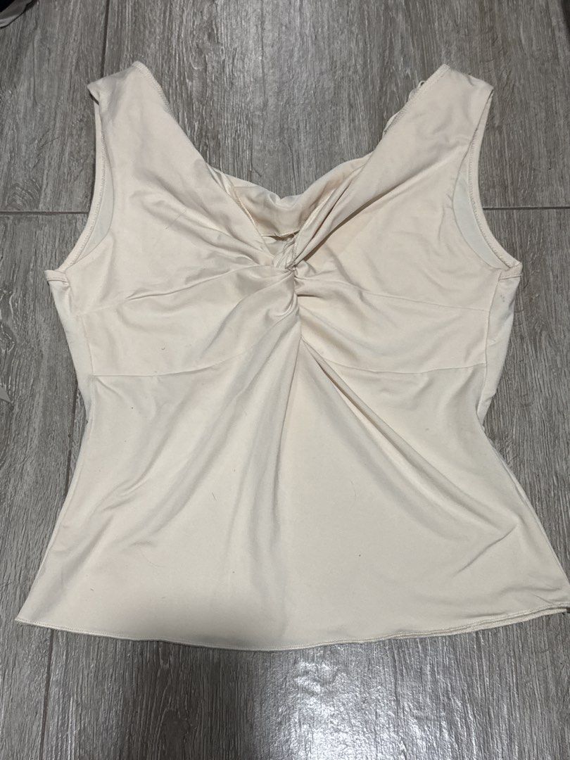 Cream Sleeveless Twisted Front Tank Top (Category: Sleeveless) located in Pateros City. Submitted by sophiahipolito (Listing ID 1469518668, Image 1). Description: - Color: Cream - Style: Sleeveless top with front twist knot detail - Neckline: V-neck - Fabric: Soft and stretchy - Fit: Comfortable, perfect for warm weather - Versatile: Easy to pair with jeans or skirts for casual days.