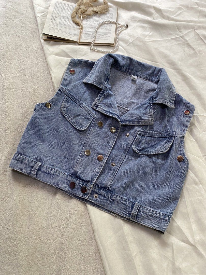 Cropped Blue Denim Vest with Front Pockets Small 34 (Category: Sleeveless) located in Poro. Submitted by joyceyuu (Listing ID 1469405473, Image 2). Description: - Color/Wash: Medium blue denim - Style: Cropped double-breasted vest with structured collar - Details: Metal hardware, two chest flap pockets - Fit: Adjustable button tabs at the waist and shoulders - Versatility: Great layering piece for casual tees or dresses - Condition: Excellent.