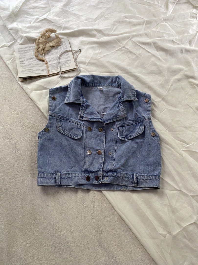 Cropped Blue Denim Vest with Front Pockets Small 34 (Category: Sleeveless) located in Poro. Submitted by joyceyuu (Listing ID 1469405473, Image 1). Description: - Color/Wash: Medium blue denim - Style: Cropped double-breasted vest with structured collar - Details: Metal hardware, two chest flap pockets - Fit: Adjustable button tabs at the waist and shoulders - Versatility: Great layering piece for casual tees or dresses - Condition: Excellent.