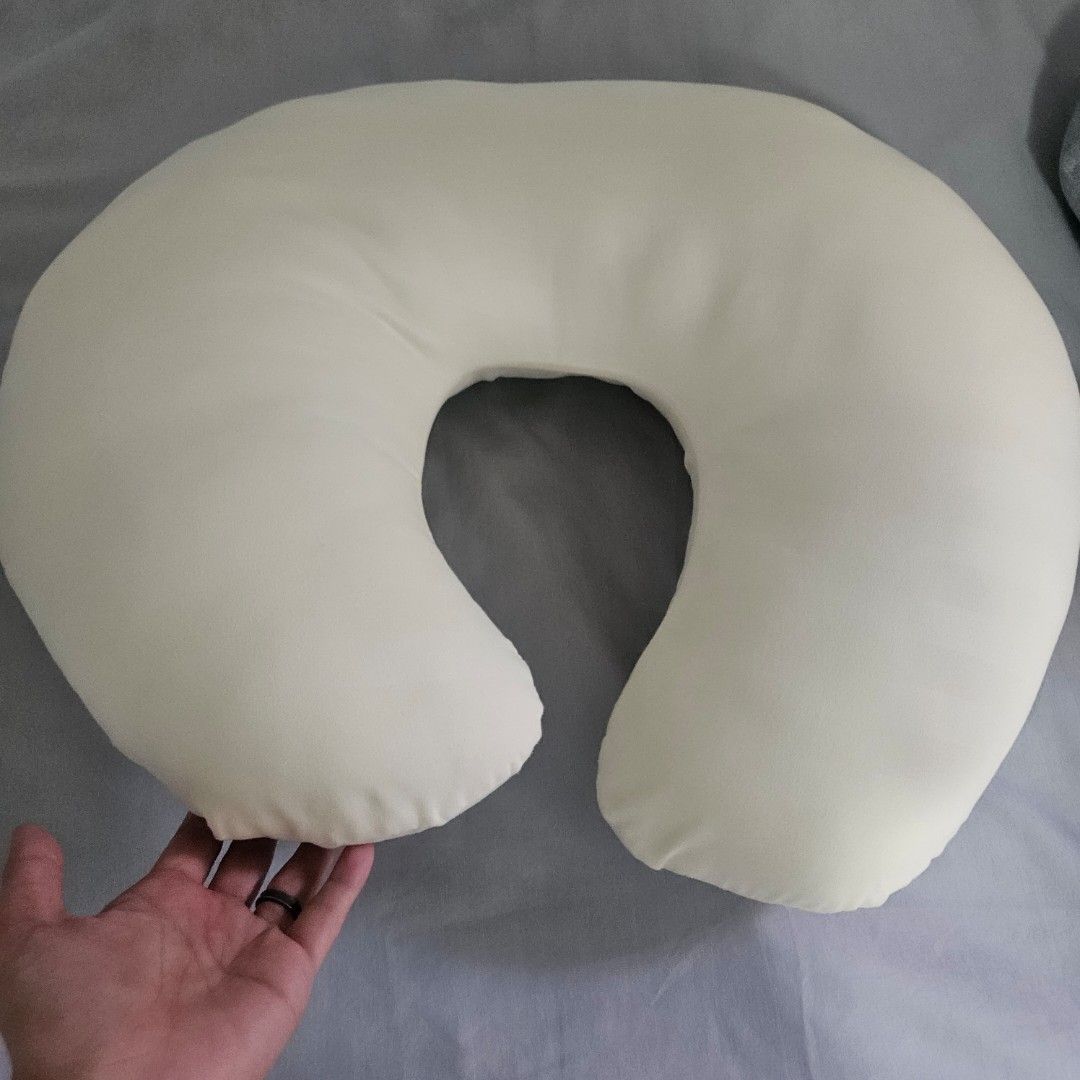 C-shaped nursing pillow baby feeding support (Category: Breastfeeding & Bottle Feeding) located in Muntinlupa City. Submitted by erikaelejido (Listing ID 1469462302, Image 1). Description: - Color: Off-white - Design: C-shaped for optimal support - Fabric: Soft, comfortable cover - Condition: Clean and ready to use - Features: Compact size, perfect for couch or bed use during feeding and lounging.