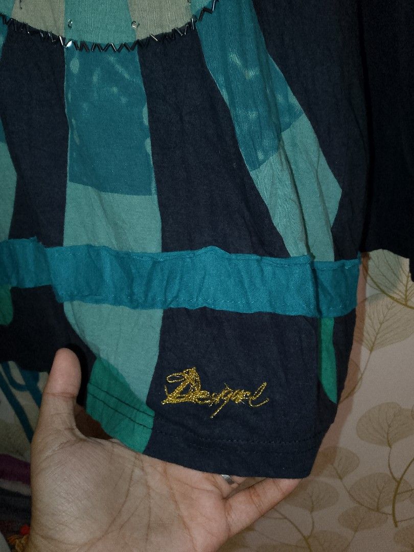 Desigual long sleeve printed top blue size M (Category: Longsleeves) located in Antipolo. Submitted by y2k_outfitters. (Listing ID 1469516285, Image 3). Description: - Brand: Desigual - Size: Medium (tag attached) - Colors: Blue, black, and teal tones - Design: V-neck collar with graphic inner pattern, large circular mandala print with beading and rhinestones on the front - Sleeves: Mismatched design (one abstract black web print, one solid black