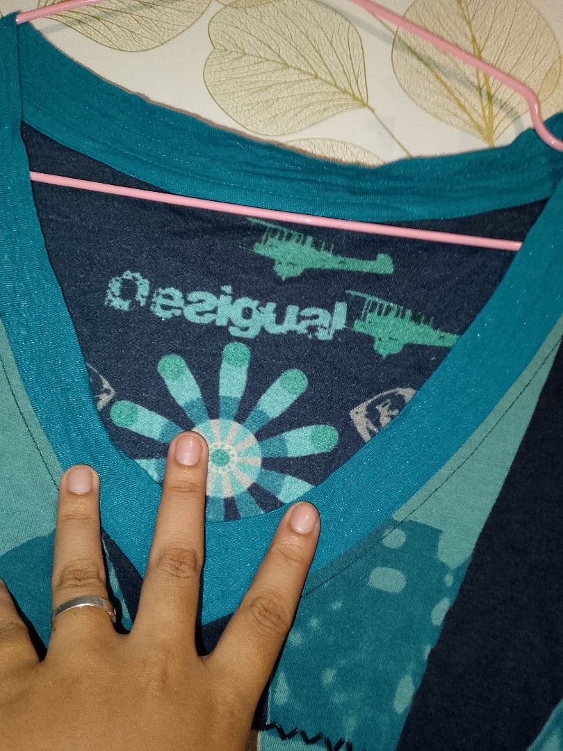 Desigual long sleeve printed top blue size M (Category: Longsleeves) located in Antipolo. Submitted by y2k_outfitters. (Listing ID 1469516285, Image 2). Description: - Brand: Desigual - Size: Medium (tag attached) - Colors: Blue, black, and teal tones - Design: V-neck collar with graphic inner pattern, large circular mandala print with beading and rhinestones on the front - Sleeves: Mismatched design (one abstract black web print, one solid black
