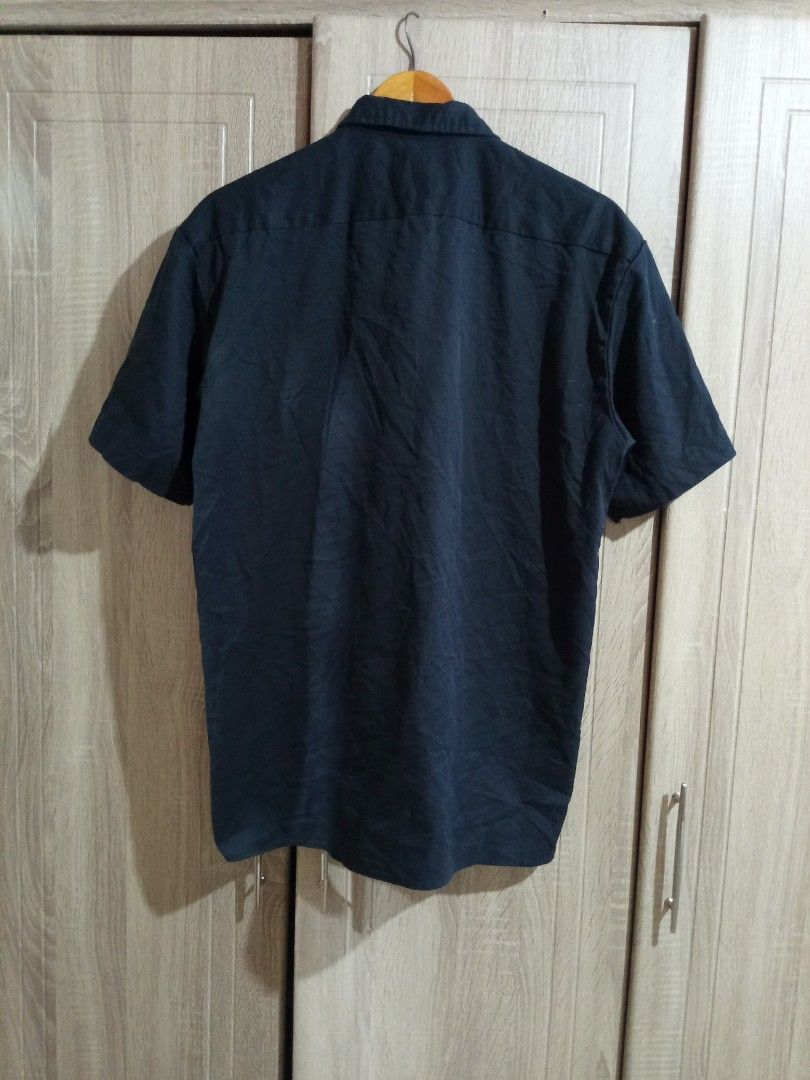 Dickies Black Short Sleeve Work Shirt (Category: Tshirts & Polo Shirts ) located in Manila. Submitted by genitereym17524 (Listing ID 1469547236, Image 2). Description: - w22 L29.5 issue maliit lang Color rate 9.5 Brand: Dickies - Item: Button-down short sleeve shirt - Color: Solid black - Size: Medium (tag at collar) - Pockets: Dual chest pockets with flaps - Details: Front button closure, woven logo patch near hem and sleeve cuff - Material: Stu