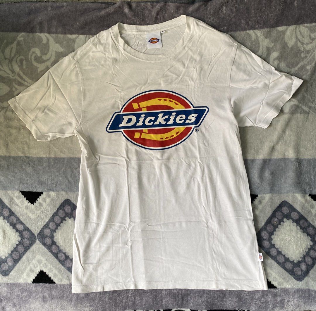 Dickies White T-Shirt Size M (Category: Tshirts & Polo Shirts ) located in Manila. Submitted by kenonskiee (Listing ID 1469550930, Image 3). Description: - Brand: Dickies - Color: Clean White - Size: Medium - Design: Large iconic horseshoe logo graphic on front chest - Details: Classic crew neck, short sleeves, and branded woven tag on lower hem - Condition: Ready to wear for everyday casual outfits.