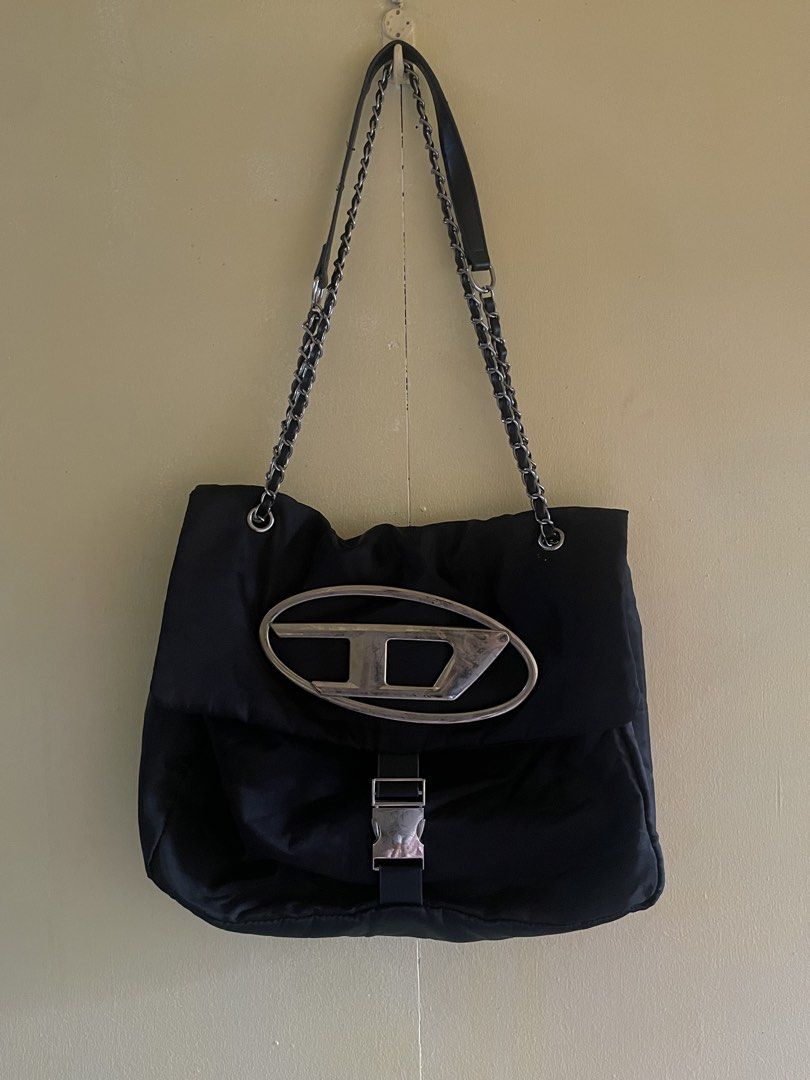 Diesel Black Shoulder Bag with Chain Strap (Category: Shoulder Bags) located in Manila. Submitted by khen23_408 (Listing ID 1469403151, Image 1). Description: - Brand: Diesel - Material: Durable black nylon with silver-tone hardware - Hardware: Iconic metal oval D logo and serial number FH-5383 stamped on the piece - Straps: Stylish dual chain and leather shoulder straps - Closure: Secure top flap with buckle accent - Interior: Roomy compartment 