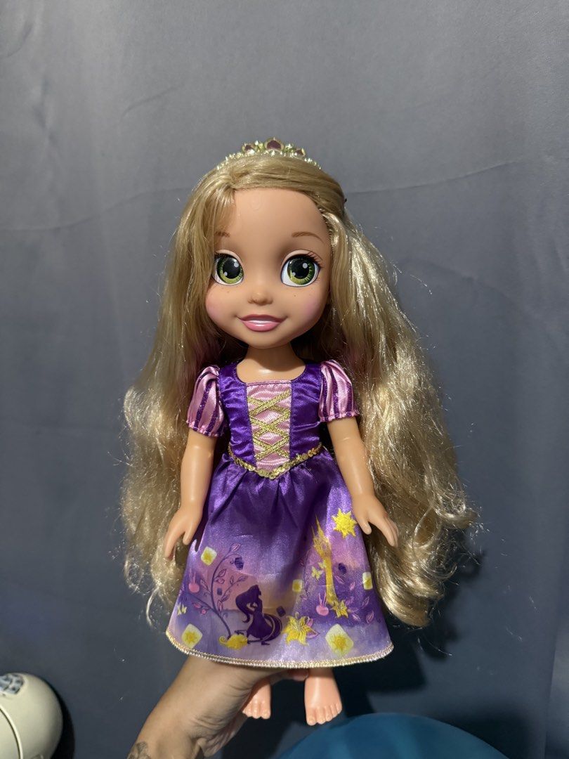 Disney Princess Rapunzel Toddler Doll (Category: Kids Toys) located in Las Pinas. Submitted by yourboki.2026 (Listing ID 1469411463, Image 1). Description: - Authentic Disney Rapunzel toddler doll - Features long, neatly brushed blonde hair and striking green eyes - Wears her signature purple dress with cute lantern graphics and gold trim - Comes with a matching small tiara - Clean outfit with vibrant, bright colors.