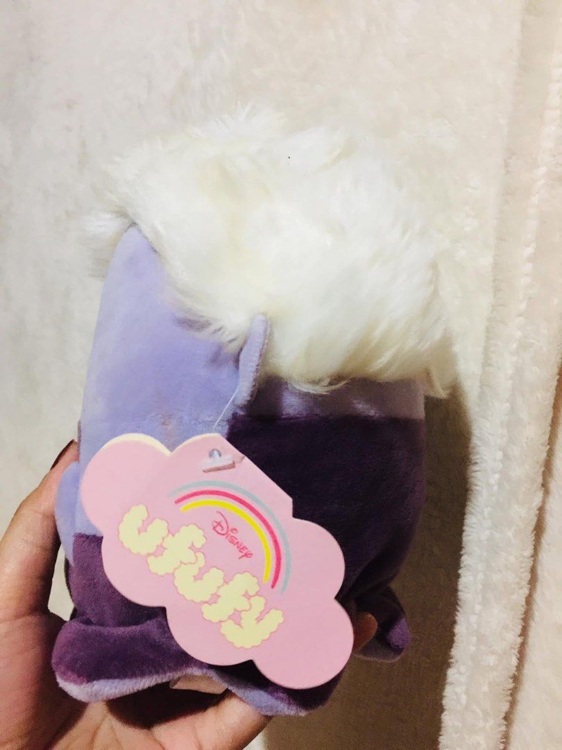Disney Ufufy Ursula Plush Toy (Category: Plushies & Soft Toys) located in Baguio. Submitted by izza_thrifty (Listing ID 1469516692, Image 2). Description: - Authentic Disney Ufufy Ursula plush toy from The Little Mermaid - Features a soft purple body, white fuzzy hair, and embroidered seashell necklace detail - Original hanging tag with Disney Ufufy rainbow branding included - Super soft fabric texture all over - Pristine, clean condition with no