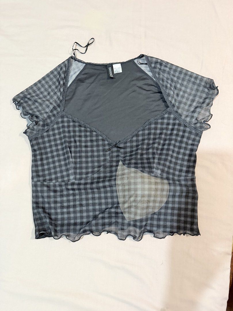 Divided H&M Black Plaid Mesh Lettuce Hem Top (Category: Sleeveless) located in Paranaque City. Submitted by hannahking36 (Listing ID 1469552263, Image 3). Description: - Brand: Divided - Size: L - Color: Black and grey plaid - Style: Y2K aesthetic, double-layered sheer mesh with solid underlayer - Details: Short sleeves with lettuce edges, sweetheart neckline, and front bow detail - Fit: Stretchy, comfortable, and flattering.