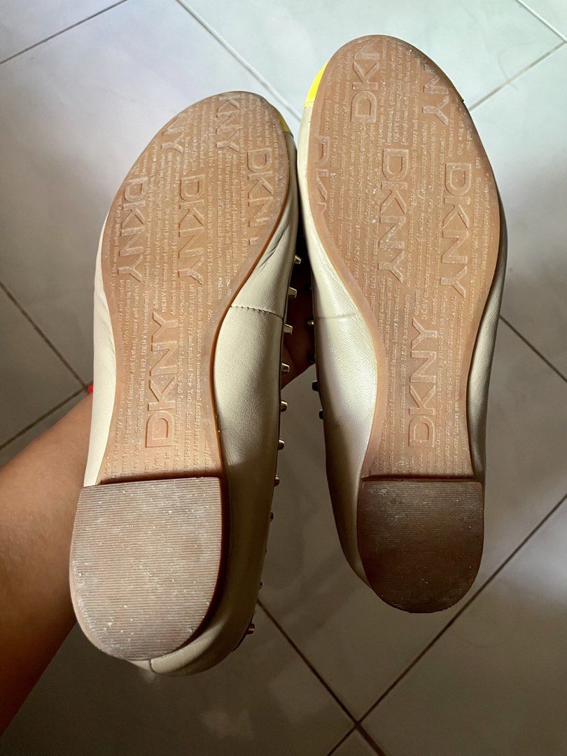 DKNY Studded Cap-Toe Leather Flats US 7.5 (Category: Flats & Sandals) located in Tabaco. Submitted by devskie (Listing ID 1469446514, Image 3). Description: - Brand: DKNY - Color: Cream with yellow cap-toes - Size: US 7.5 / EU 38 / UK 5 - Material: Leather upper with man-made balance - Details: Metal stud trim, slip-on style, low heel - Condition: Light wear on soles, overall well-maintained.