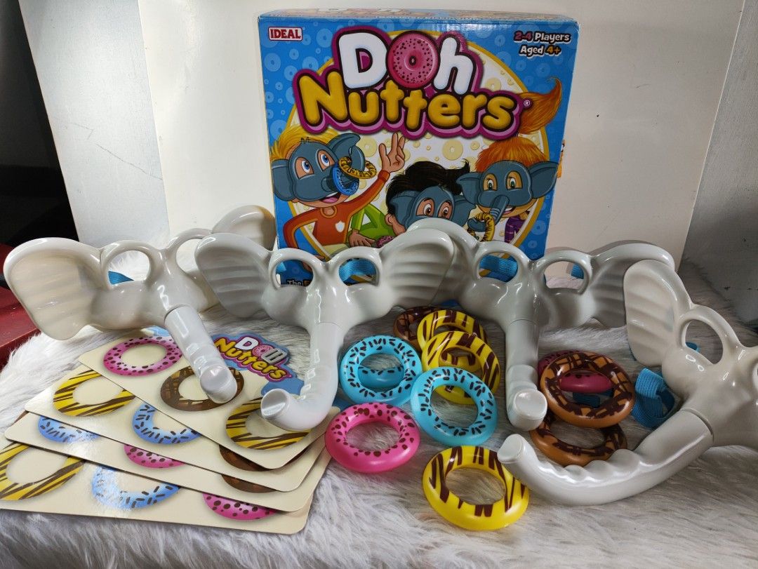 Doh Nutters Game Ideal 2-4 Players (Category: Board Games & Puzzles) located in Cavite. Submitted by tinetaclesss (Listing ID 1469497305, Image 1). Description: - Vintage Doh Nutters board game by Ideal - Perfect for 2 to 4 players, ages 4 and up - Includes original box, 4 elephant snouts with adjustable straps, colorful plastic donut rings, and game cards - All pieces are clean, complete, and ready for your next game night - Fun and active famil