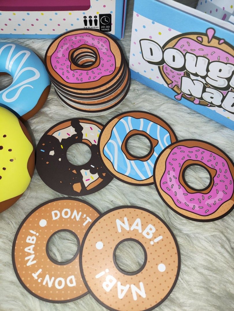 Dough Nab The Game by G Games (Category: Board Games & Puzzles) located in Cavite. Submitted by tinetaclesss (Listing ID 1469497891, Image 3). Description: - Game: Fun family doughnut matching and grabbing board game - Players: 3 to 6 players, ages 8 and up - Playtime: Fast-paced 20 to 30 minutes per round - Inclusions: 3 squishy toy doughnuts, 60 doughnut cards, winner's hat, turn tracker, and rule book complete .