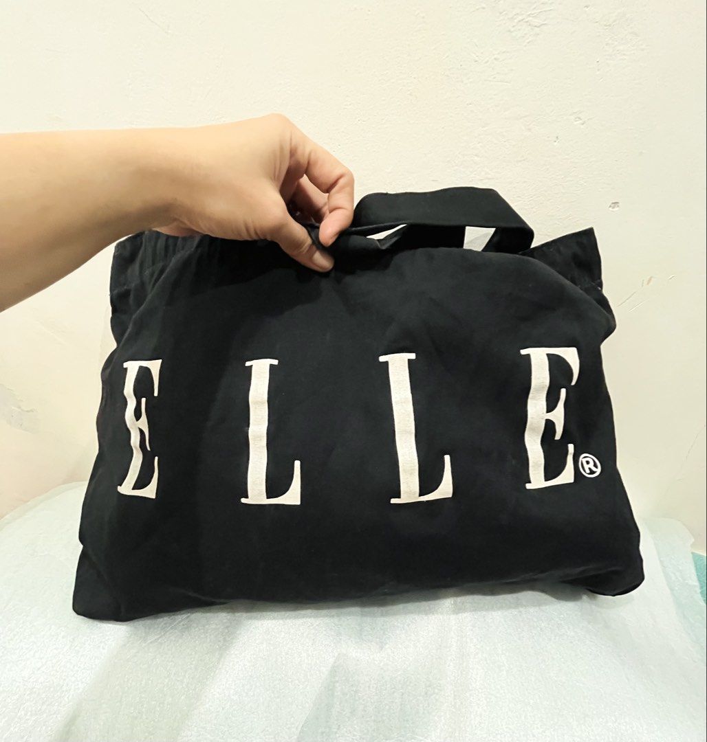 ELLE Black Tote Bag (Category: Tote Bags) located in Talisay. Submitted by cherylu (Listing ID 1469570229, Image 2). Description: - Brand: ELLE - Color: Black canvas with bold white logo lettering - Design: Open top with a roomy main compartment and dual shoulder straps - Details: Includes official interior brand tags - Style: Simple, chic, and versatile everyday carryall.