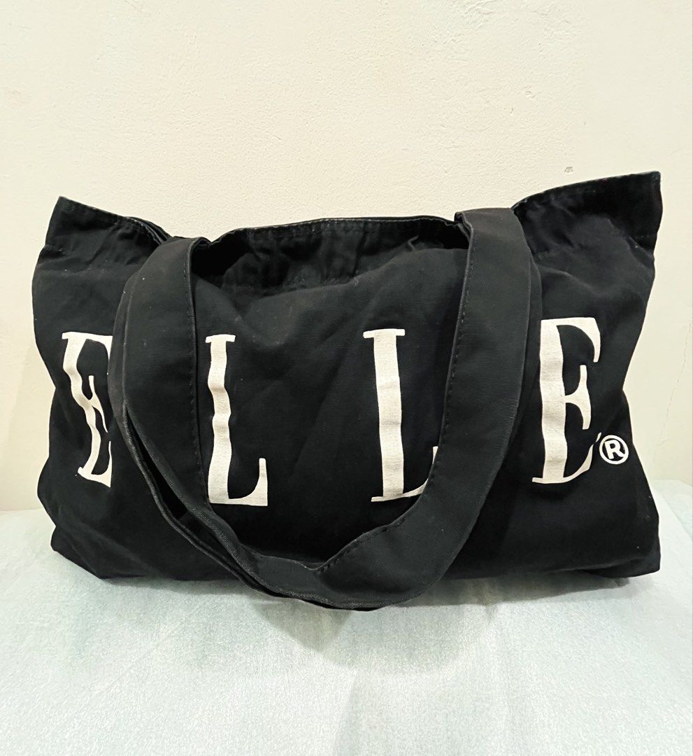 ELLE Black Tote Bag (Category: Tote Bags) located in Talisay. Submitted by cherylu (Listing ID 1469570229, Image 1). Description: - Brand: ELLE - Color: Black canvas with bold white logo lettering - Design: Open top with a roomy main compartment and dual shoulder straps - Details: Includes official interior brand tags - Style: Simple, chic, and versatile everyday carryall.