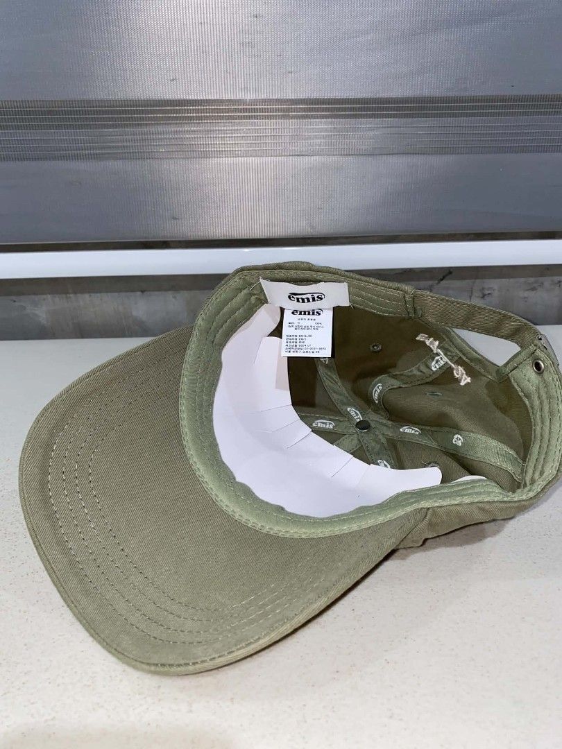 Emis Green Every Moment is Special Baseball Cap (Category: Caps & Hats) located in Baler. Submitted by mariokush193815 (Listing ID 1469453117, Image 3). Description: - Brand: Emis - Color: Olive green cotton - Front: Embroidered heart patch with Emis branding and white script text ("every moment is special") - Back: E17-24 embroidery with an adjustable strap and metal clasp - Condition: Brand new, unworn, with interior tags intact and crisp inner