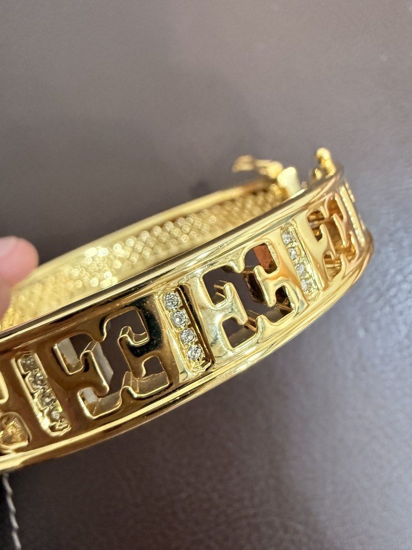 ESCADA Gold Tone Rhinestone Cutout Bangle Bracelet (Category: Bracelets) located in Quezon City. Submitted by anille (Listing ID 1469555248, Image 3). Description: - Elegant gold tone bangle bracelet with a chic cutout pattern - Embedded sparkling rhinestones between stations for extra shine - Textured back half design with a secure hinge clasp closure - Inner circumference measures approximately 7 inches - Features a shiny polished finish with m