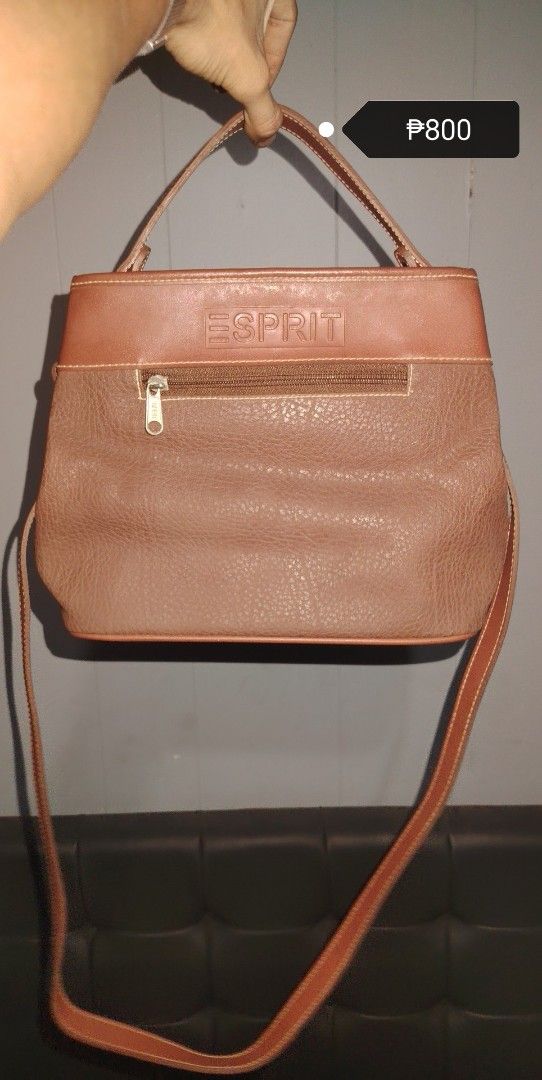 ESPRIT brown leather shoulder bag handbag (Category: Shoulder Bags) located in Manila. Submitted by chuaniki (Listing ID 1469536419, Image 1). Description: - Brand: Esprit - Material: Brown leather with clean stitching - Pockets: Convenient front zipper pocket - Logo: Debossed Esprit logo on top panel - Straps: Includes top handle and long adjustable strap - Wear: Can be worn on the shoulder or crossbody.