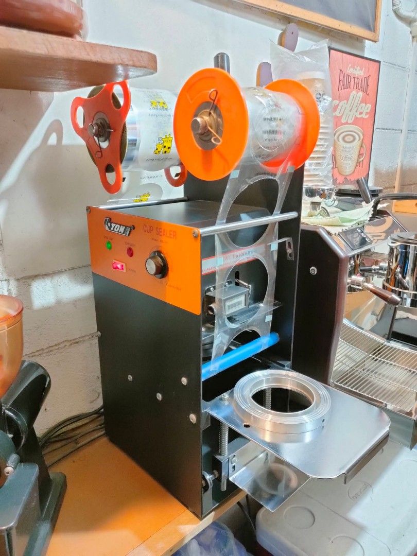 ETON Manual Cup Sealing Machine (Category: Beverages) located in Marikina City. Submitted by janddglamcollections (Listing ID 1469485763, Image 2). Description: - Model: ETON Semi-Automatic Cup Sealer Heavy-duty black body - Feature: Temperature controller knob, heat and temp indicator lights - Operation: Manual side handle with a smooth sliding cup tray - Ideal For: Bubble tea shops, cafes, amd juice bars - Power: Standard plug-in ready No Issue