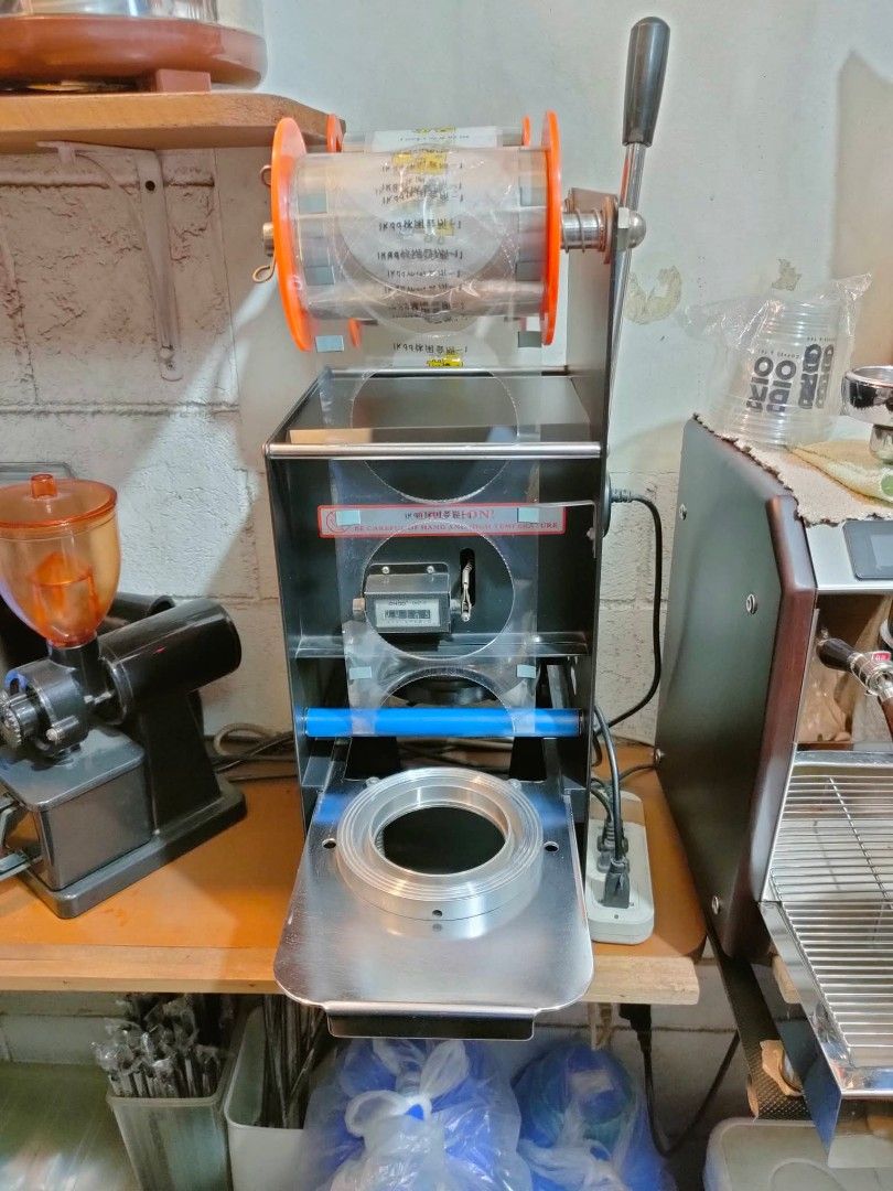 ETON Manual Cup Sealing Machine (Category: Beverages) located in Marikina City. Submitted by janddglamcollections (Listing ID 1469485763, Image 1). Description: - Model: ETON Semi-Automatic Cup Sealer Heavy-duty black body - Feature: Temperature controller knob, heat and temp indicator lights - Operation: Manual side handle with a smooth sliding cup tray - Ideal For: Bubble tea shops, cafes, amd juice bars - Power: Standard plug-in ready No Issue