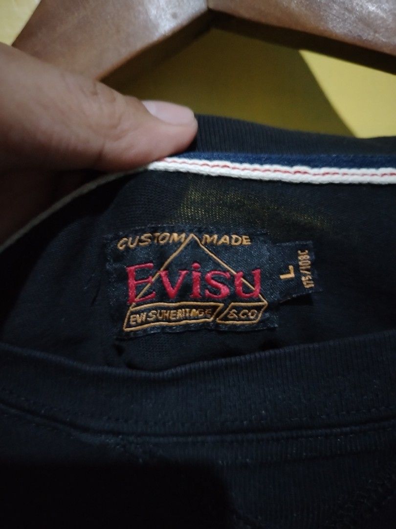Evisu Force Parasquad Black Graphic T-Shirt (Category: Tshirts & Polo Shirts ) located in Caloocan City. Submitted by vincefresn21903 (Listing ID 1469500157, Image 3). Description: - Brand: Evisu - Model: Force Parasquad Tee - Color: Black - Size: Large (L) - Material: Comfortable cotton - Details: Bold white chest graphic, orange tag near hem, colorful embroidered patches across back shoulders, contrast stitching on inner collar - Condition: Exc