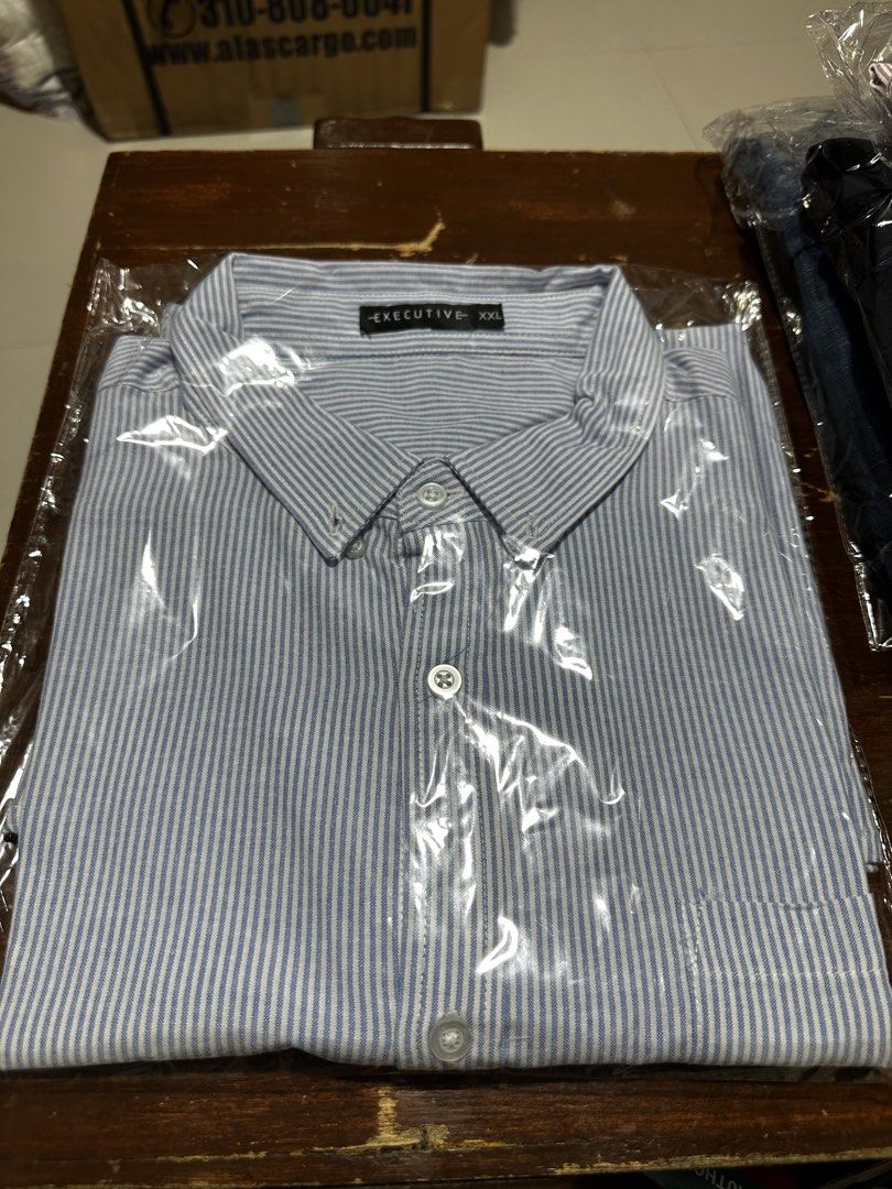 Executive Blue Striped Short Sleeve Button Down Shirt XXL (Category: Tshirts & Polo Shirts ) located in Quezon City. Submitted by breakstuf50 (Listing ID 1469473056, Image 1). Description: - Brand: Executive - Size: XXL - Design: Blue and white vertical stripes - Features: Left chest pocket, crisp collar, and button-front closure - Measurements: Length ~31.5 inches, Chest width ~25 inches across - Versatile: Perfect for casual wear or the office 