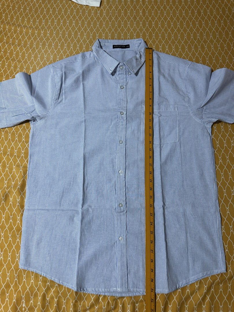 Executive Blue Striped Short Sleeve Button Down Shirt XXL (Category: Tshirts & Polo Shirts ) located in Quezon City. Submitted by breakstuf50 (Listing ID 1469473056, Image 2). Description: - Brand: Executive - Size: XXL - Design: Blue and white vertical stripes - Features: Left chest pocket, crisp collar, and button-front closure - Measurements: Length ~31.5 inches, Chest width ~25 inches across - Versatile: Perfect for casual wear or the office 