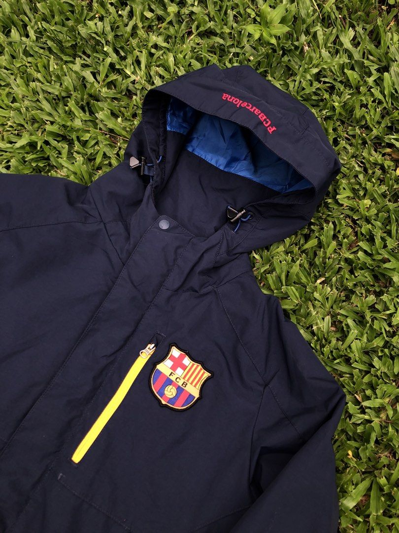 FC Barcelona Navy Blue Waterproof Hooded Jacket (Category: Coats, Jackets and Outerwear) located in Kabasalan. Submitted by hamugaway (Listing ID 1469567041, Image 2). Description: - Official FC Barcelona merchandise - Color: Navy blue with bright blue lining and hood interior - Size: 160 cm - Material: 100% nylon outer - Features: Bright yellow zip pocket, front zip with storm flap, and adjustable drawstrings on hood - Condition: Brand new/Excel