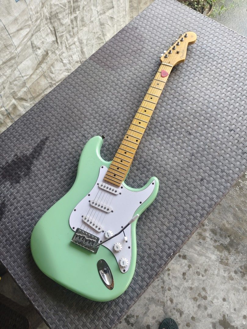Fender Strat Mint Green copy (Category: Musical Instruments) located in Manila. Submitted by donsantiag93175 (Listing ID 1469401025, Image 1). Description: - For sale Fender Stratocaster copy Low action With Trust rod - Finish: Bright Mint Green with white pickguard and knobs - Neck & Fretboard: Maple with classic skunk stripe - Pickups: 3-single-coil setup for versatile tone - Hardware: Standard tremolo bridge (whammy bar included) and standard 