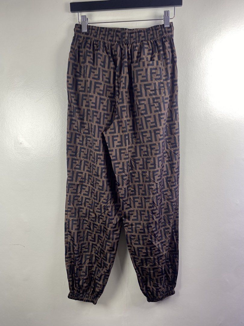 Fendi Roma FF Logo Brown Nylon Jogger Pants (Category: Joggers) located in Manila. Submitted by declutterpromax (Listing ID 1469450809, Image 3). Description: - Fendi Roma pants in brown with all-over FF logo pattern - Material: Lightweight and durable 100% nylon - Waistband: Elastic with adjustable black drawstring and metallic aglets - Details: Rubber Fendi Roma patch on the left leg, rear patch pocket, and ribbed ankle cuffs - Size: Large - Mo