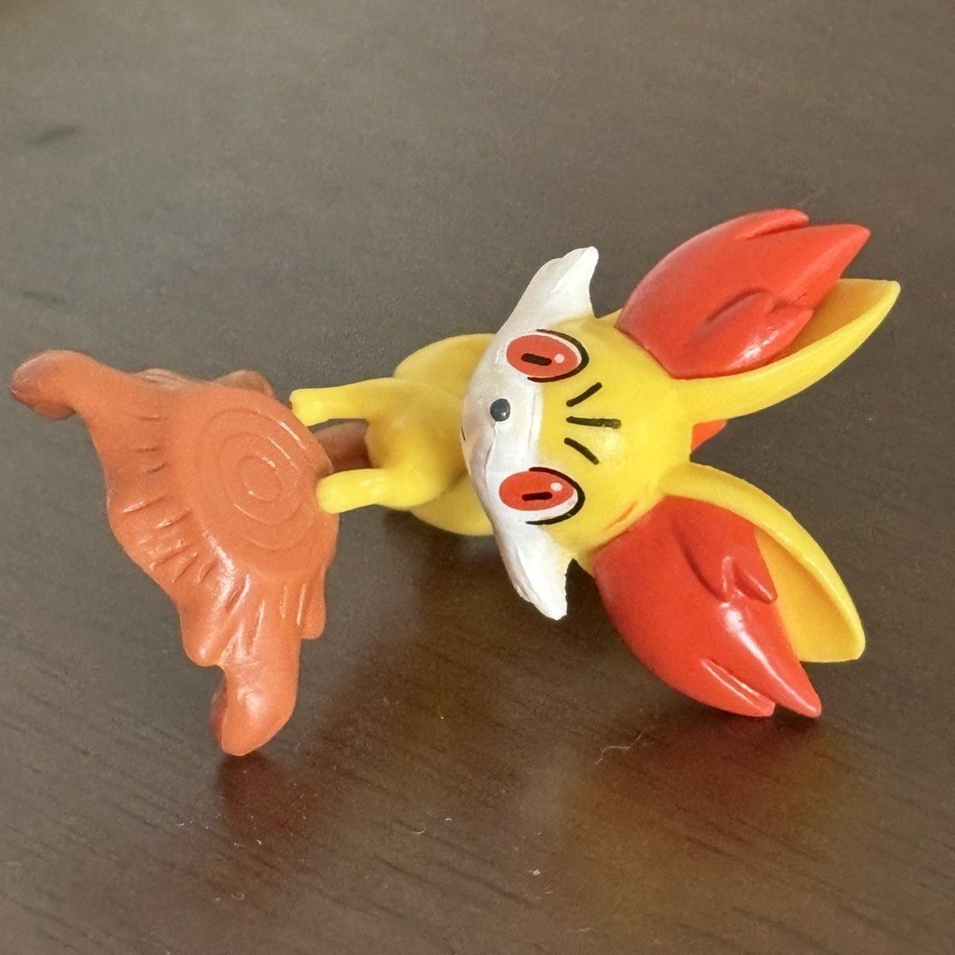 Fennekin Pokemon Figure with Tree Stump Base (Category: Figurines & Statues) located in Manila. Submitted by aobacafe (Listing ID 1469454560, Image 2). Description: - Character: Fennekin from Pokémon - Design: Bright yellow, orange, and white colors posed on a brown tree stump base - Inclusion: Original yellow foil packaging wrapper - Condition: Loose toy item, excellent for display or collection - Shipping: Fast shipping available across the Phi
