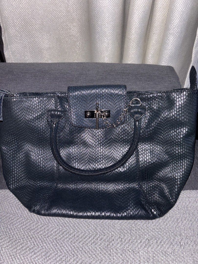 FINO Leatherware Davos Bag (Category: Shoulder Bags) located in Calamba. Submitted by victorangelogabriel (Listing ID 1469540407, Image 3). Description: • Embossed Leather: Crafted from genuine leather with a prominent, glossy reptile/snakeskin-embossed pattern. • Deep Colorway: Styled in a dark tone, typically available in charcoal black or deep navy blue. • Signature Logo Plate: Features a polished, rectangular silver-tone metal branding plate 