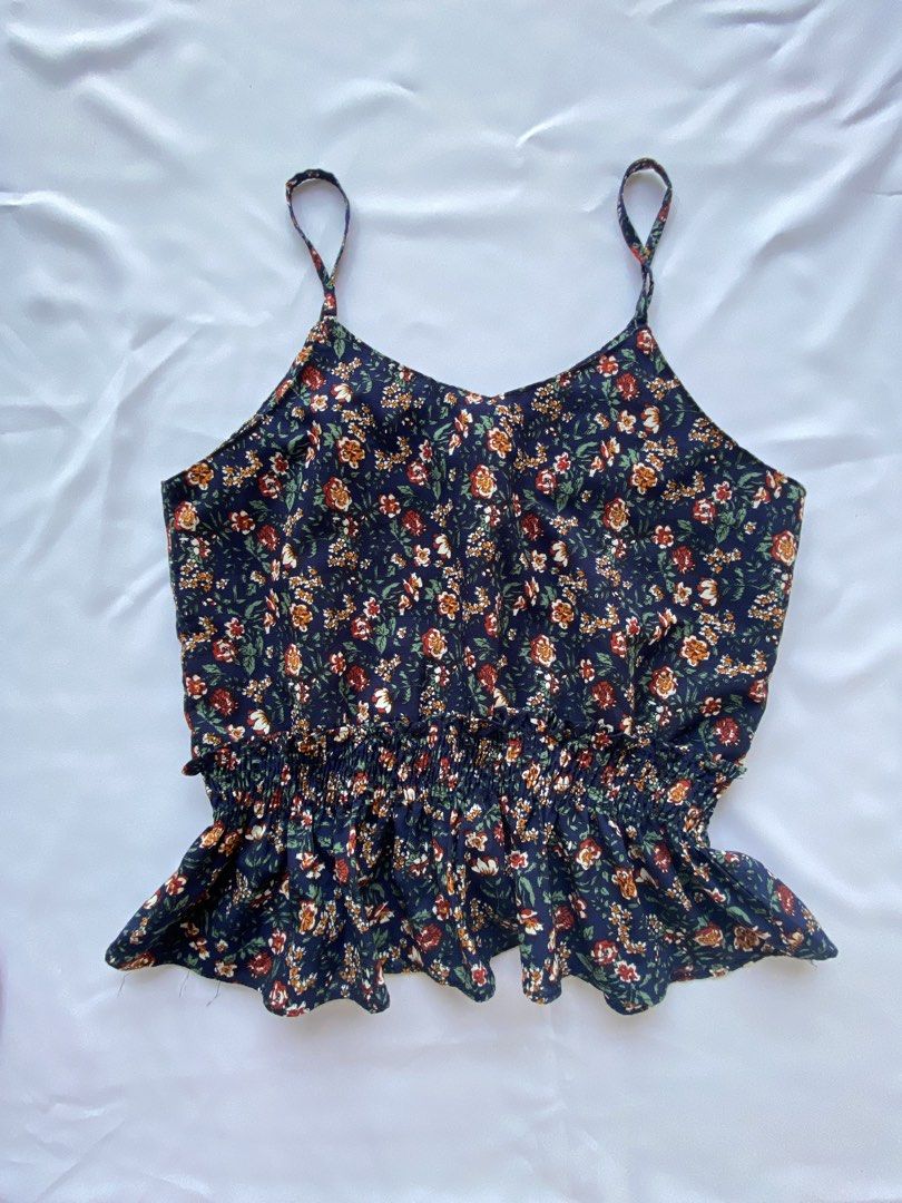 Floral Print Cami and Solid Rust Tank Top Bundle (Category: Sleeveless) located in Cauayan City . Submitted by alt_olshop4 (Listing ID 1469539040, Image 2). Description: - Bundle includes 2 cute and lightweight casual camisoles - Piece 1: Navy blue base with tiny red/white flowers and a flattering smocked waist - Piece 2: Solid rust orange shade featuring thin straps and a slightly flared hem - Easy to mix and match for effortless everyday stylin
