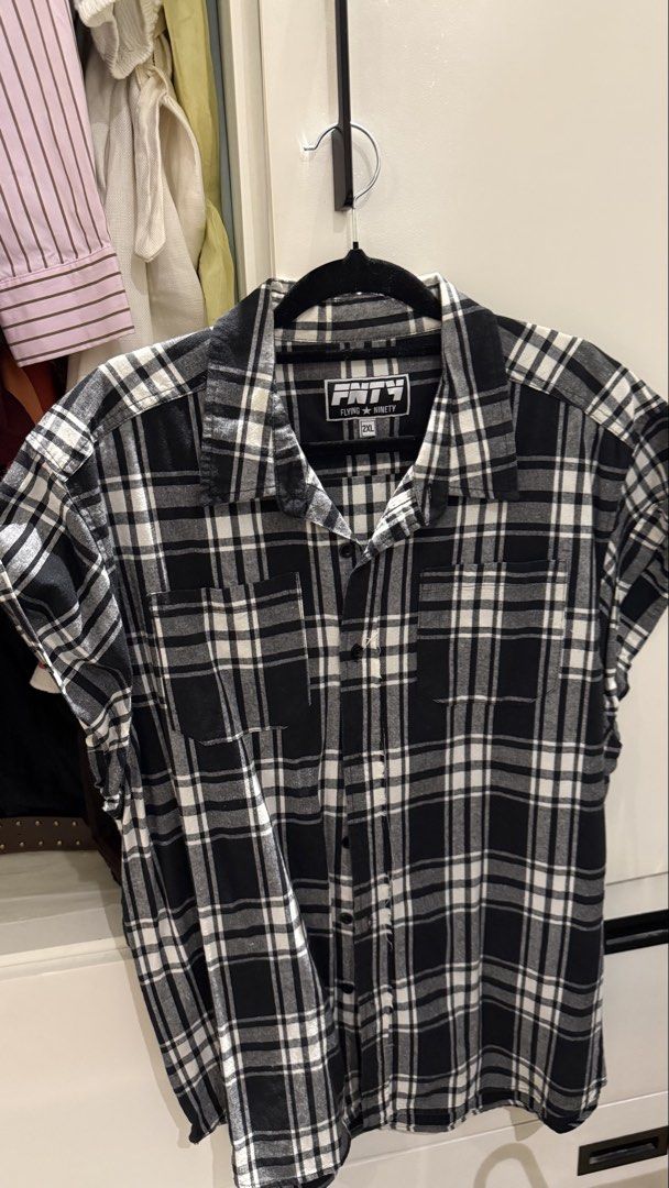 Flying Ninety Black White Plaid Sleeveless Button Down 2XL (Category: Sleeveless) located in Paranaque City. Submitted by secondstories_ (Listing ID 1469477177, Image 1). Description: - Brand: Flying Ninety - Style: Semi-Sleeveless button-down shirt - Pattern: Black and white classic plaid/checkered - Features: Two functional chest pockets - Size: Marked 2XL on neck label - Versatile: Easy to layer or style on its own.