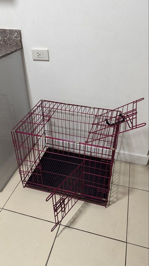 Foldable metal dog cage crate with removable tray (Category: Storage Boxes & Baskets) located in Taguig. Submitted by ImpulzBuyer (Listing ID 1469411126, Image 2). Description: - Color: Stylish pink metal wire - Size: Approx. 25 inches long x 18 inches wide - Design: Double doors with secure latches and convenient top carry handle - Convenience: Folds completely flat for easy storage and transport - Includes: Removable black plastic bottom tray f
