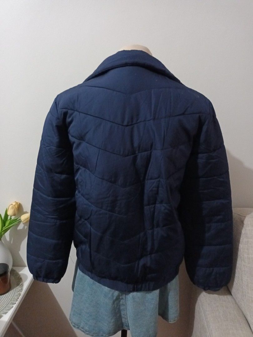 Forever 21 Navy Blue Puffer Jacket Size M (Category: Coats, Jackets and Outerwear) located in Quezon. Submitted by ja8720 (Listing ID 1469478230, Image 3). Description: - Brand: Forever 21 - Size: Medium - Color: Navy blue - Design: Chevron pattern stitching - Features: Full front silver zip, stand-up collar, and two zipped waist pockets - Style: Casual, warm, and easy to pair with everyday outfits.