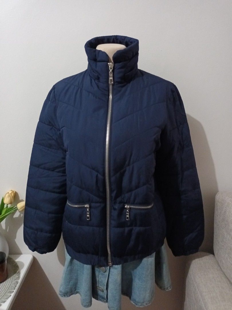 Forever 21 Navy Blue Puffer Jacket Size M (Category: Coats, Jackets and Outerwear) located in Quezon. Submitted by ja8720 (Listing ID 1469478230, Image 1). Description: - Brand: Forever 21 - Size: Medium - Color: Navy blue - Design: Chevron pattern stitching - Features: Full front silver zip, stand-up collar, and two zipped waist pockets - Style: Casual, warm, and easy to pair with everyday outfits.