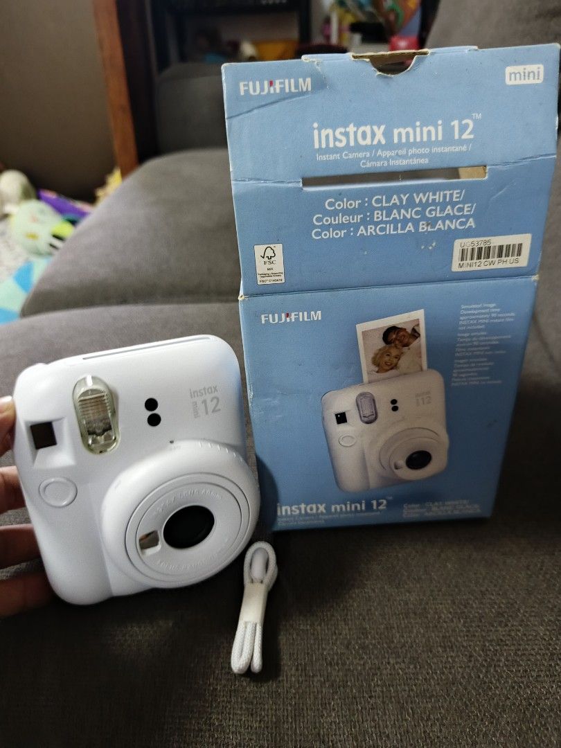 Fujifilm Instax Mini 12 Instant Camera Clay White (Category: Cameras) located in Agdangan. Submitted by gentleeagle_785f8e (Listing ID 1469397134, Image 2). Description: - Model: Fujifilm Instax Mini 12 - Color: Clay White - Condition: Camera body is clean and white; original box shows slight storage wear - Features: Easy point-and-shoot, twist lens to power on and activate close-up mode - Inclusions: Original box and wrist strap - Perfect for qu