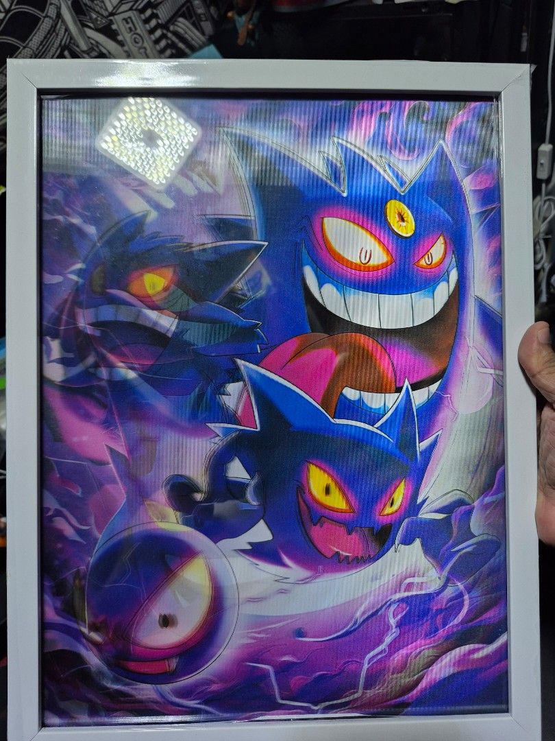 Gengar Lenticular Art Framed Pokémon Print (Category: Art & Prints) located in Las Pinas. Submitted by iamjaym (Listing ID 1469521695, Image 2). Description: - 3D lenticular Gengar art piece with perspective-shifting effect - Features multiple Gengar and Gastly figures in a striking blue and purple palette - Comes encased in a clean, ready-to-display white frame - Includes a blue hanging string attached to the back panel for easy mounting - Stand