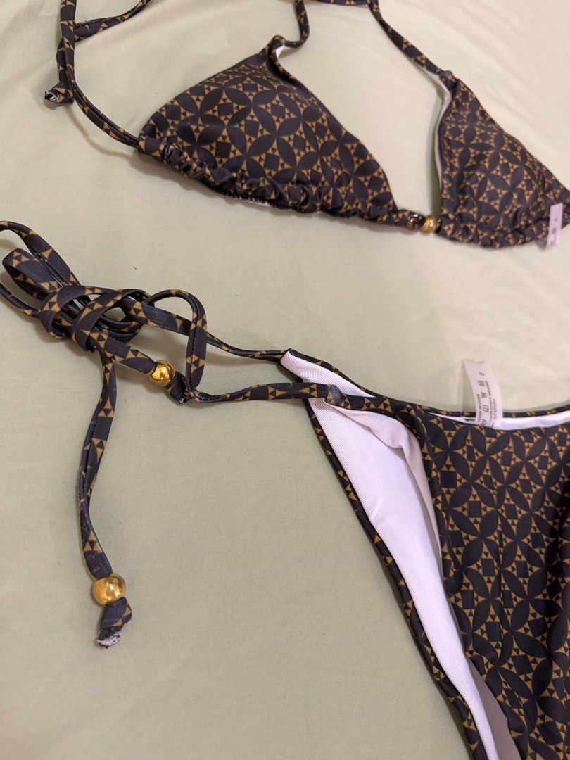 Geometric Triangle Bikini Set with Gold Bead Details (Category: Bikinis & Swimsuits) located in Makati City. Submitted by andzr. (Listing ID 1469543229, Image 2). Description: - Brand new with tags (never worn) - Stylish dark brown and tan geometric print - Triangle top and adjustable tie-side bottoms - Chic shiny gold and dark bead details on string ends - Fully lined with comfortable white inner lining.