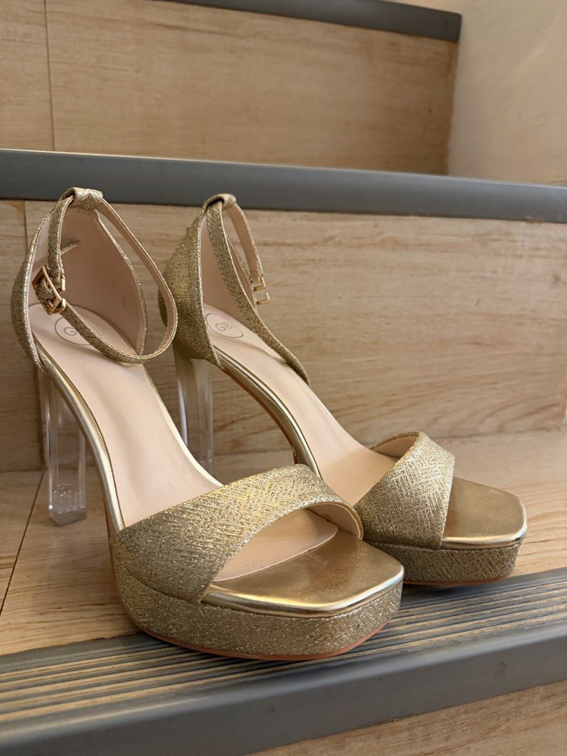 Gibi Gold Glitter Platform Heels (Category: Heels) located in Paranaque City. Submitted by camcs (Listing ID 1469507798, Image 2). Description: * Size: 36 * Condition: Used once * Inclusions: No box * Design: Gold glitter finish, clear block heels, platform sole, and ankle strap.
