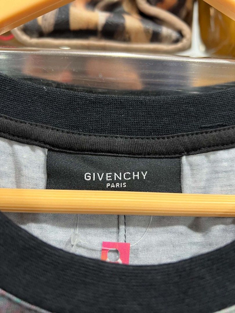Givenchy Paris Abstract Face Graphic Print T-Shirt (Category: Shirts) located in Urdaneta. Submitted by jayceegarage (Listing ID 1469546565, Image 2). Description: - Brand: Givenchy Paris - Item: Short sleeve t-shirt with striking abstract graphic print (black, white, red, and orange tones) - Collar: Classic black crew neck - Material: 100% cotton main fabric, polyester second fabric lining - Origin: Made in Portugal - Style Code: 12S 7242 651 - 