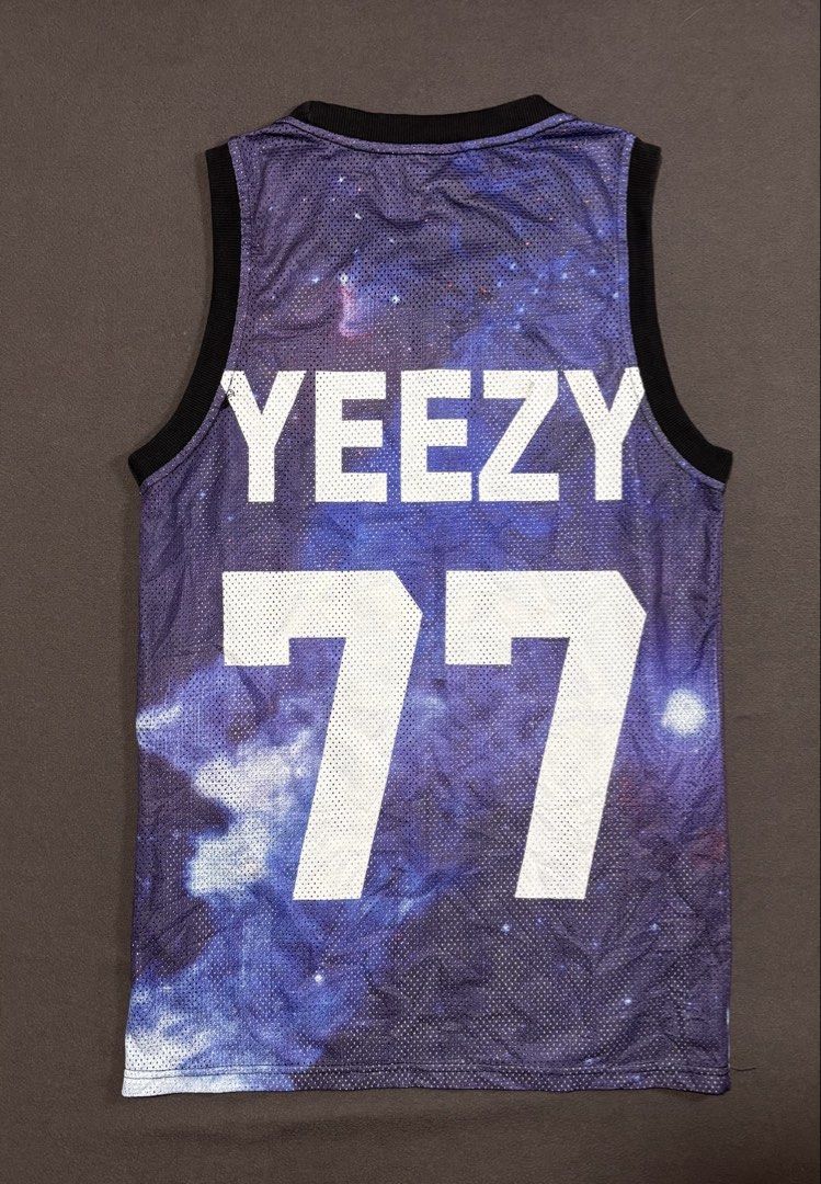Givenchy Yeezy 77 Space Graphic Tank Top (Category: Sleeveless) located in Mabalacat. Submitted by _limitlessfashion (Listing ID 1469406956, Image 2). Description: - Brand: Givenchy - Size Large on tag - Length 28 - Width 18 - Style: Basketball mesh tank top - Color/Design: Purple space galaxy print - Front Detail: All-Seeing Eye pyramid graphic with 'DON'T TRUST ANYONE' text - Back Detail: 'YEEZY' and number 77 in bold white lettering - Trim: Ri