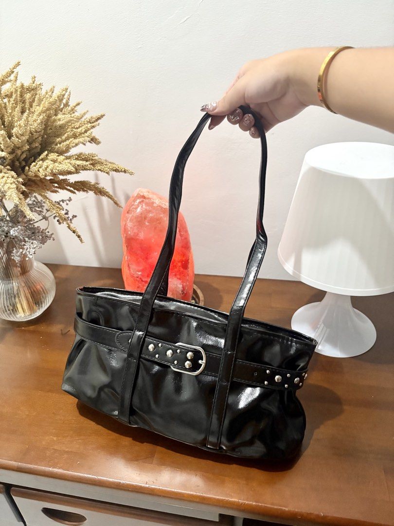 Glossy shoulder bag with buckle and stud details (Category: Shoulder Bags) located in Binangonan. Submitted by blairmayie (Listing ID 1469444536, Image 1). Description: - Material: Glossy faux leather with a chic slouchy design - Carry: Comfortable double top handles - Details: Edgy silver-tone studs and decorative front buckle strap - Closure: Secure top zipper to keep your items safe - Size: Spacious enough for your daily essentials, great for 