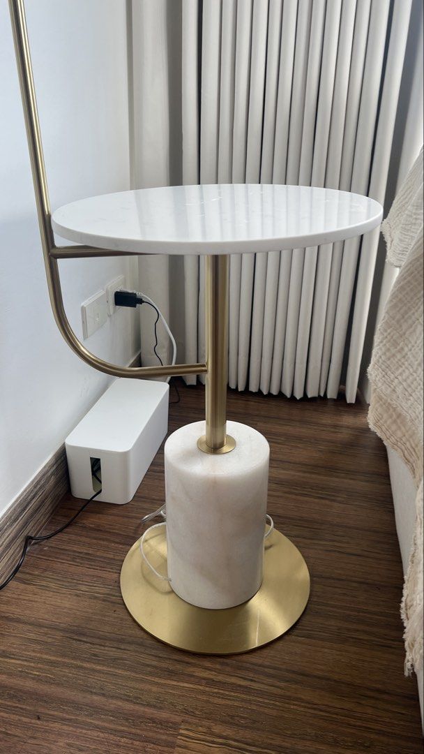 Gold Floor Lamp with White Marble Side Table (Category: Lighting) located in Pasig City. Submitted by thestylesisters (Listing ID 1469421065, Image 2). Description: - 2-in-1 design: Combines a reading light and a small coffee table - Space-saving: Takes up very little floor space, perfect beside a sofa or bed - Elegant aesthetic: Gold tone metal finish with a white marble top - Sturdy build: Features a heavy cylindrical marble base - Adjustable l
