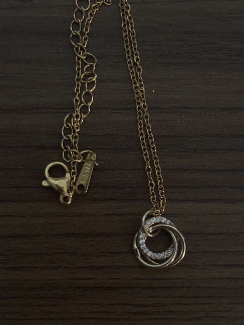 Gold-tone Interlocking Circles Pendant Necklace with Crystals (Category: Necklaces) located in San Juan City. Submitted by hellokitty_454 (Listing ID 1469475678, Image 1). Description: - Design: Gold-tone necklace featuring three interlocking circles - Detail: One circle beautifully paved with sparkling clear crystals - Material: Durable S-STEEL (marked near the clasp) - Closure: Delicate link chain with an adjustable extension and secure lobster