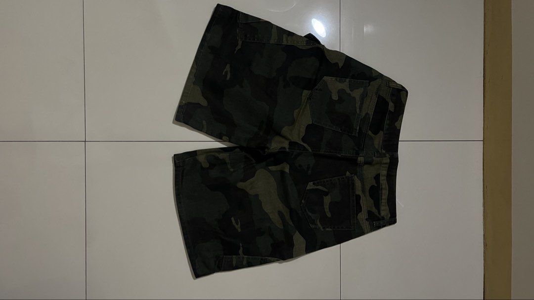 Green Camouflage Cargo Shorts with Pockets (Category: Shorts) located in Quezon City. Submitted by oddwhale.282847 (Listing ID 1469419159, Image 2). Description: - Color & Pattern: Green camouflage - Material: Sturdy, durable cotton - Size: 12 Inches waist - Waist: Regular fit with button closure and zipper fly - Pockets: Multiple side utility pockets and two back pockets - Style: Ideal for casual wear and outdoor activities.