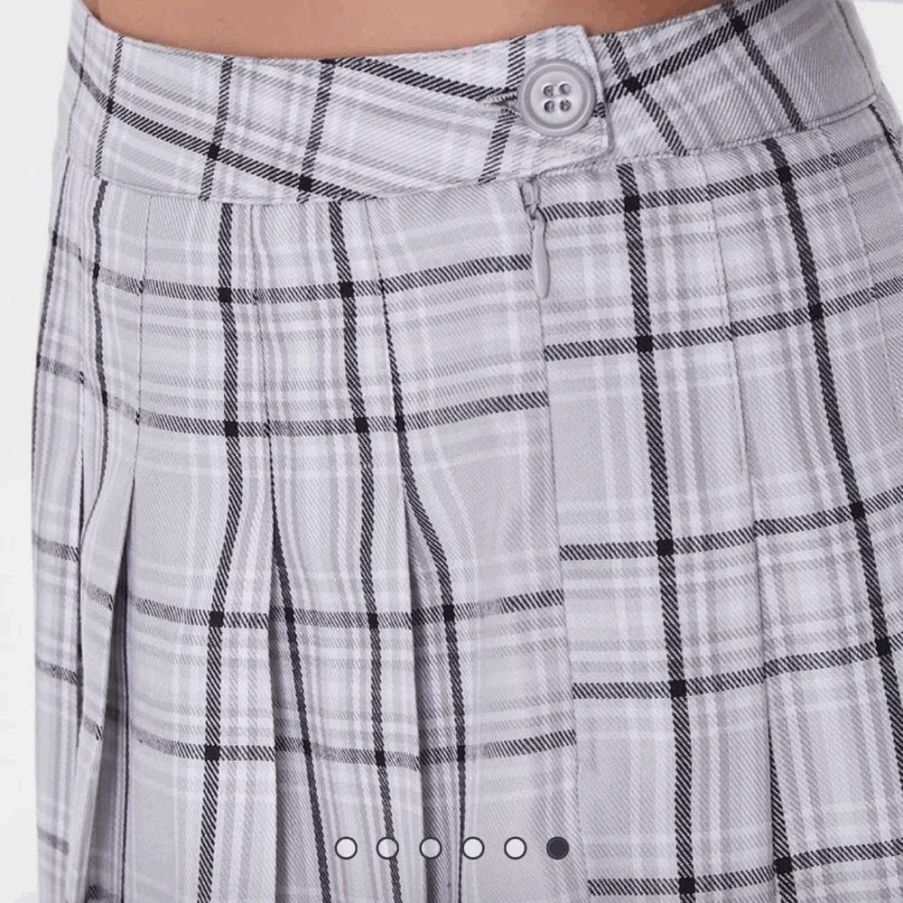 Forever 21 Grey Plaid Pleated Mini Skirt (Category: Skirts) located in Quezon City. Submitted by earthtodior (Listing ID 1469544189, Image 2). Description: - Style: High-waisted mini pleated skirt - Pattern: Classic plaid (white, black, and light grey) - Closure: Side button and zipper - Features: Structured all-around pleats and clean stitching - Pair with: Crop tops or basic tees for a trendy look.