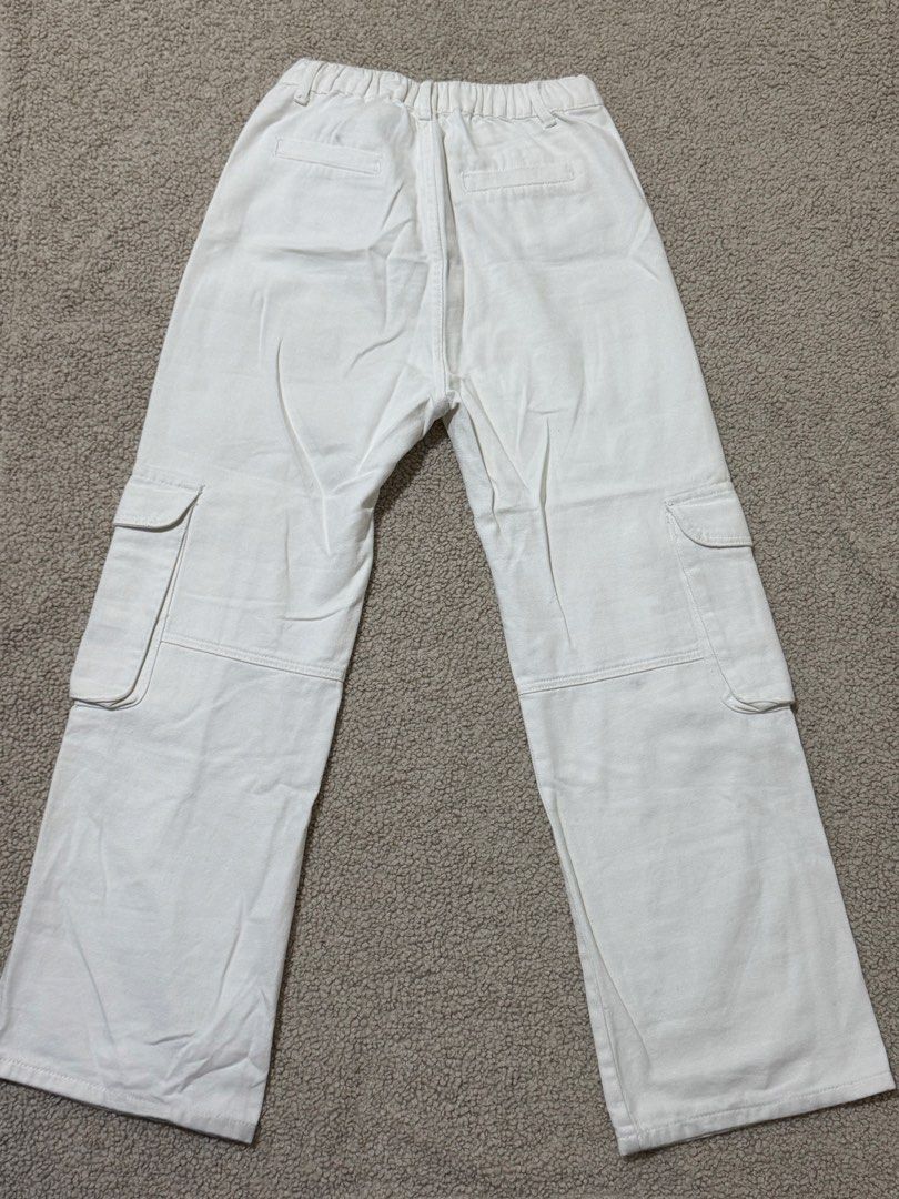 Gtw Urban White Cargo Pants (Category: Jeans) located in Las Pinas. Submitted by ann.co. (Listing ID 1469545345, Image 2). Description: - Brand/Item: GTW Urban White Cargo Pants - Material: Durable cotton twill fabric - Fit: Relaxed straight leg with an elastic waistband on the back - Closure: Zip fly with button closure - Pockets: Multiple utility pockets on front, back, and sides - Flaw: Minor smudge spot visible near the right knee seam.