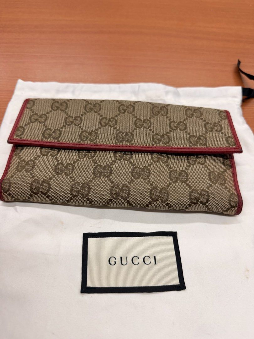 Gucci GG Canvas Long Wallet Red Trim (Category: Luxury Bags & Wallets) located in Quezon City. Submitted by ellamenopi (Listing ID 1469394808, Image 2). Description: - Authentic Gucci monogram canvas long wallet - Stylish red leather trim and matching snap flap closure - Luxurious red leather interior lining with gold-tone hardware - Plenty of card slots and compartments for organization - Comes with original white Gucci dust bag - Condition: Exc