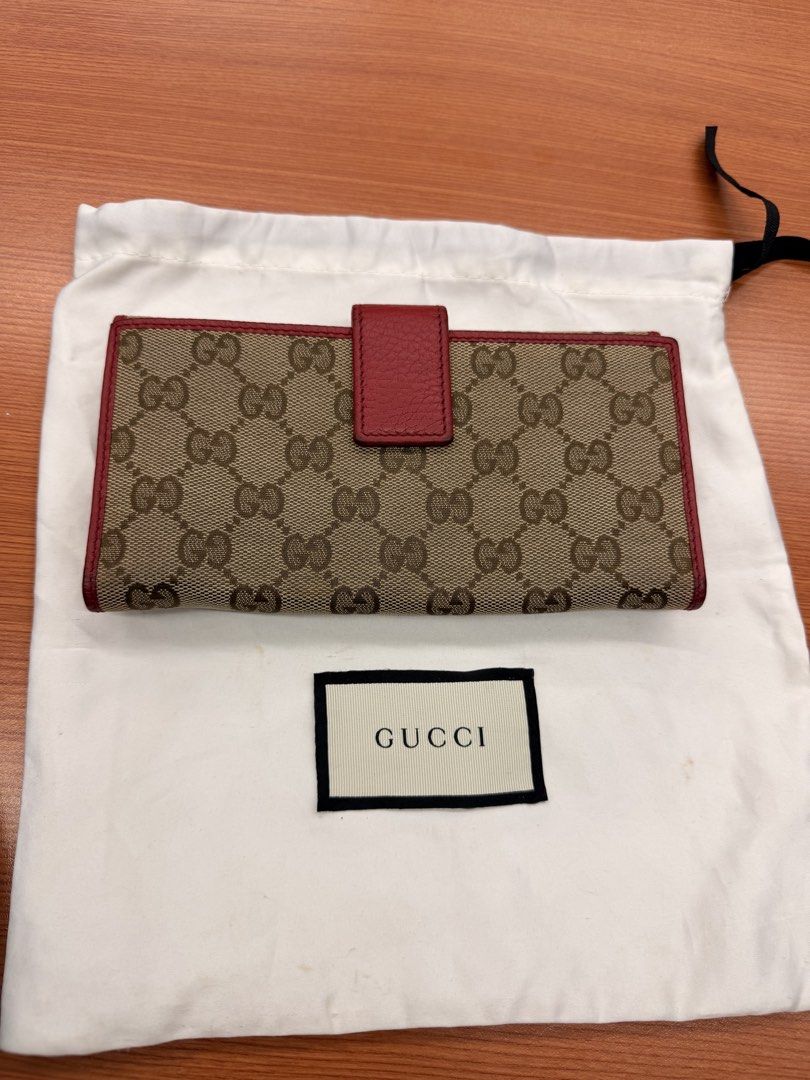 Gucci GG Canvas Long Wallet Red Trim (Category: Luxury Bags & Wallets) located in Quezon City. Submitted by ellamenopi (Listing ID 1469394808, Image 1). Description: - Authentic Gucci monogram canvas long wallet - Stylish red leather trim and matching snap flap closure - Luxurious red leather interior lining with gold-tone hardware - Plenty of card slots and compartments for organization - Comes with original white Gucci dust bag - Condition: Exc