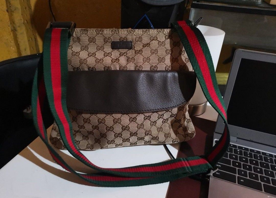 Gucci GG Canvas Messenger Bag with Web Strap UNISEX (Category: Luxury Bags & Wallets) located in Santa Rosa. Submitted by laria.maria (Listing ID 1469428849, Image 1). Description: - Authentic Gucci messenger bag in classic GG monogram canvas - Features a stylish brown leather front pocket - Signature green and red web stripe adjustable canvas shoulder strap - Spacious interior compartment, perfect for daily essentials - Clean interior lining wit